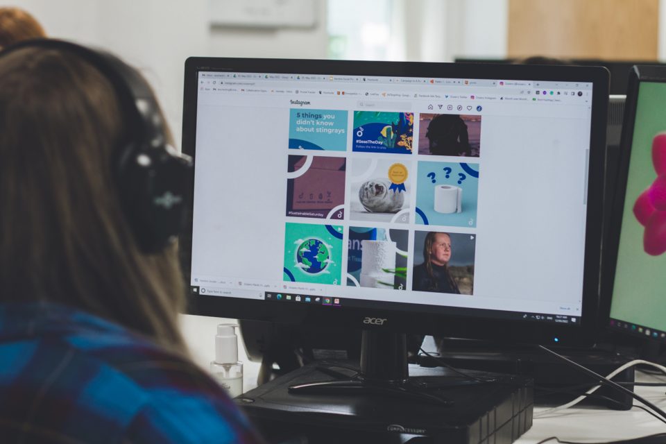 a team member at their computer looking at a social platform