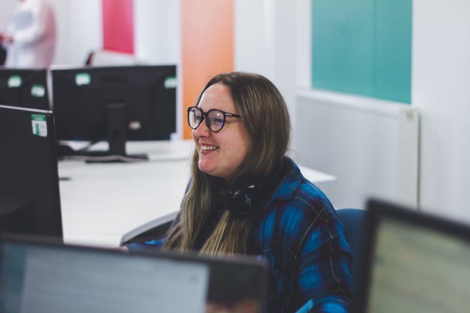 a member of Click consult's social team, smiling at their desk