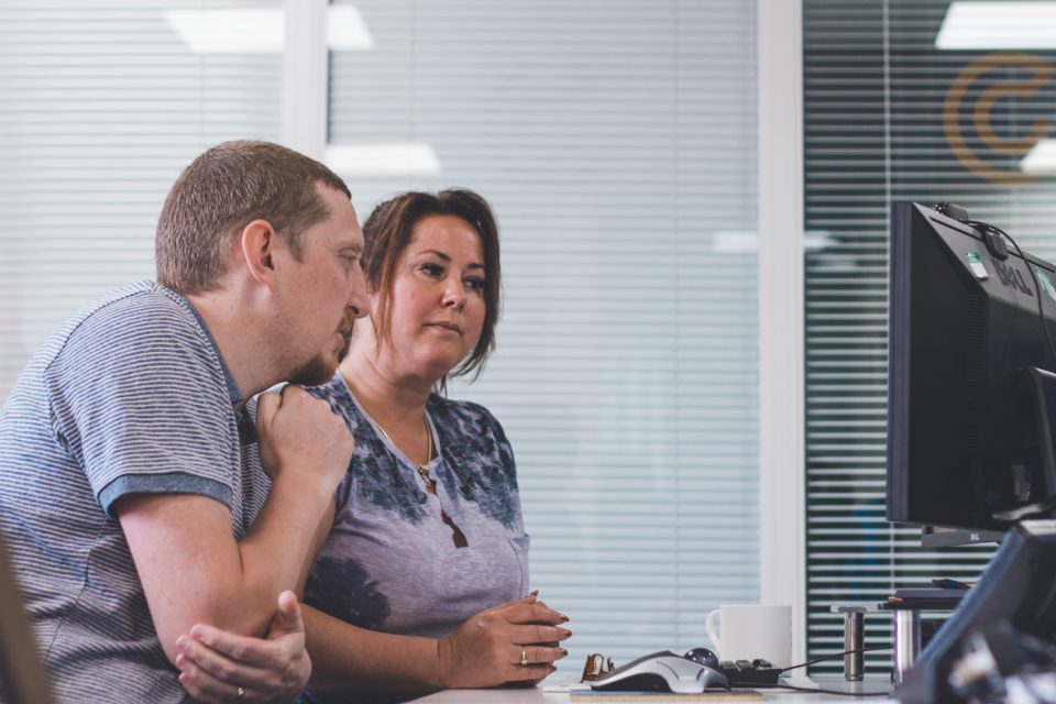 two team members looking at a screen